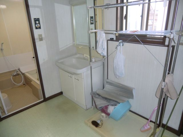 Washroom. Vanity and a washing machine inside the yard