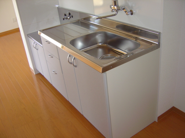 Kitchen. There are hanging cupboard & range hood to the top. 