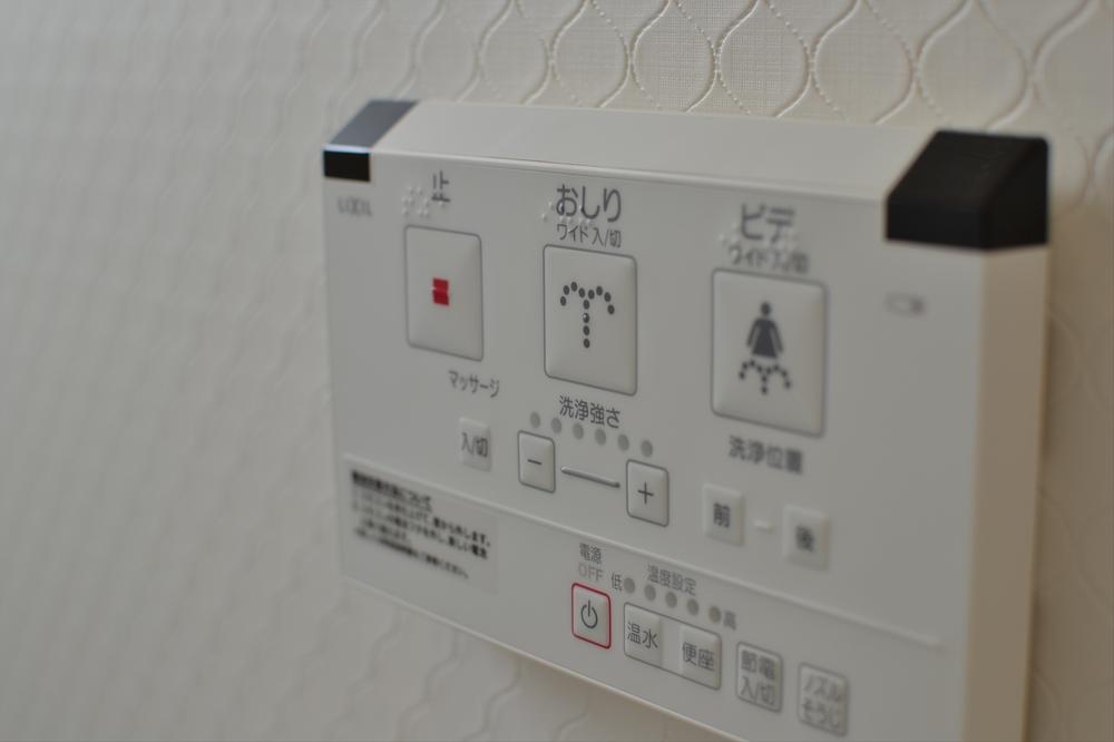 Other Equipment. Shower toilet with a wall-mounted remote control.