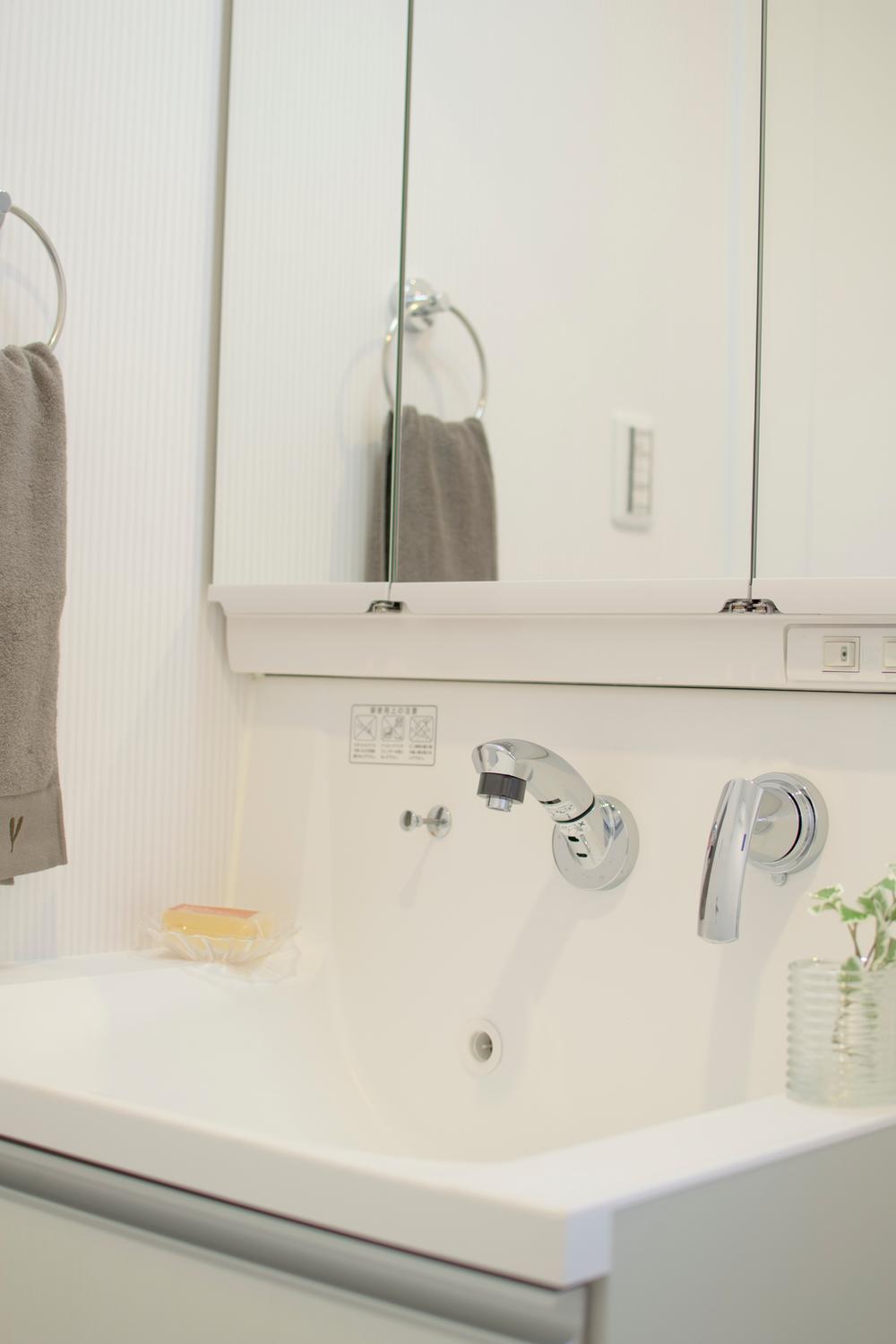 Wash basin, toilet. Wide three-sided mirror vanity. 