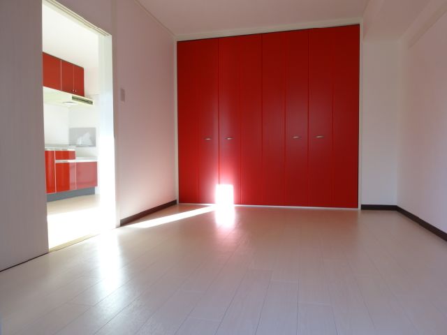 Living and room. It is spread of the room there is a red closet.