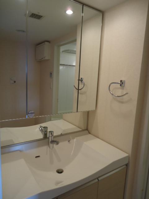 Wash basin, toilet. Three-sided mirror with vanity shooting