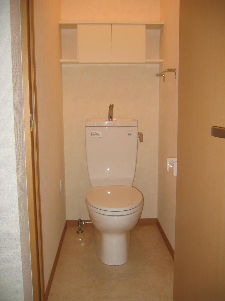 Toilet. Conveniently comes with a door with a small storage rack in the upper part