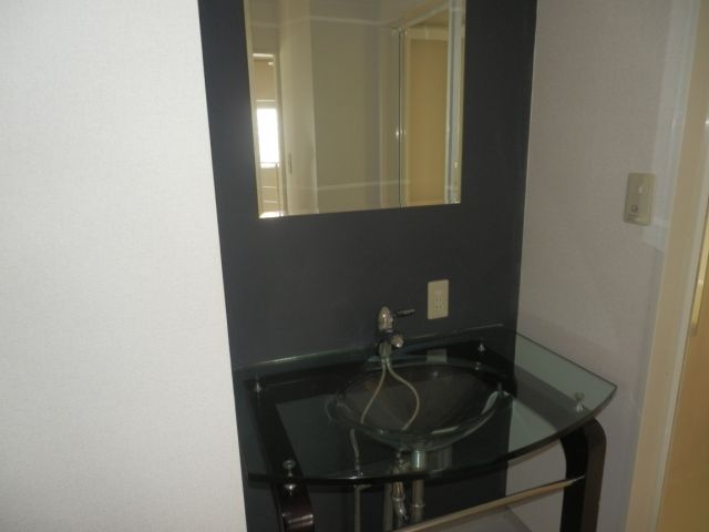 Washroom. Wash basin and transparent type on a black wall, It is a stylish basin. 