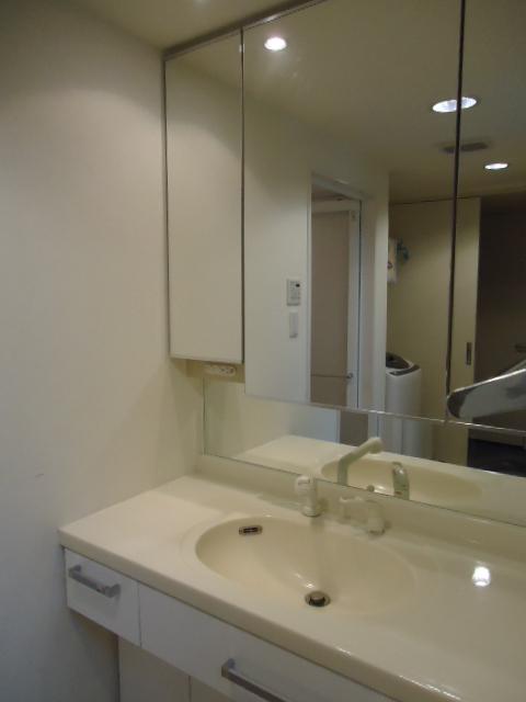 Wash basin, toilet. Three-sided mirror vanity that the installed of