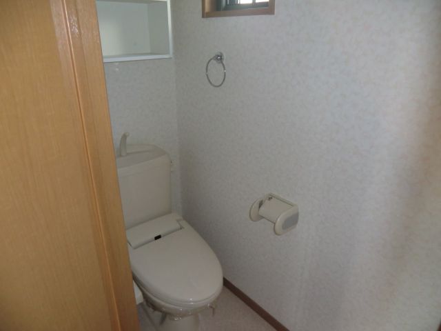 Toilet. Toilet and is equipped with storage shelves and a small window with a shower!