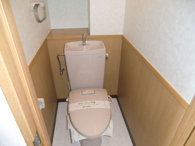 Toilet. It is a toilet with a power source that is equipped with a storage rack to the top