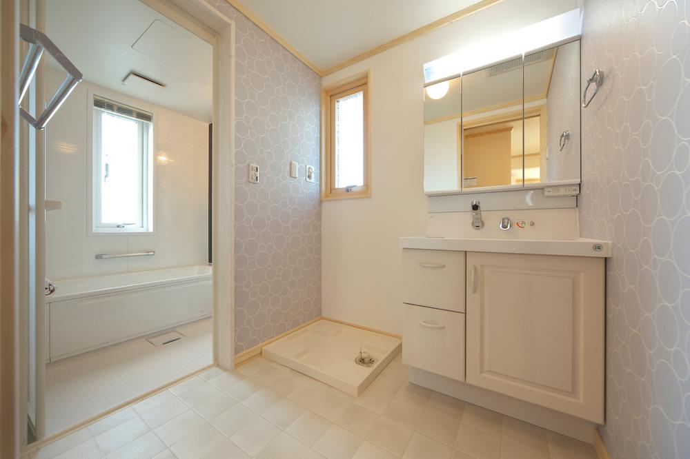 Bathroom. Clean and full of a feeling of vanity space. Vanity and unified wallpaper in pale shades is a sophisticated atmosphere. 