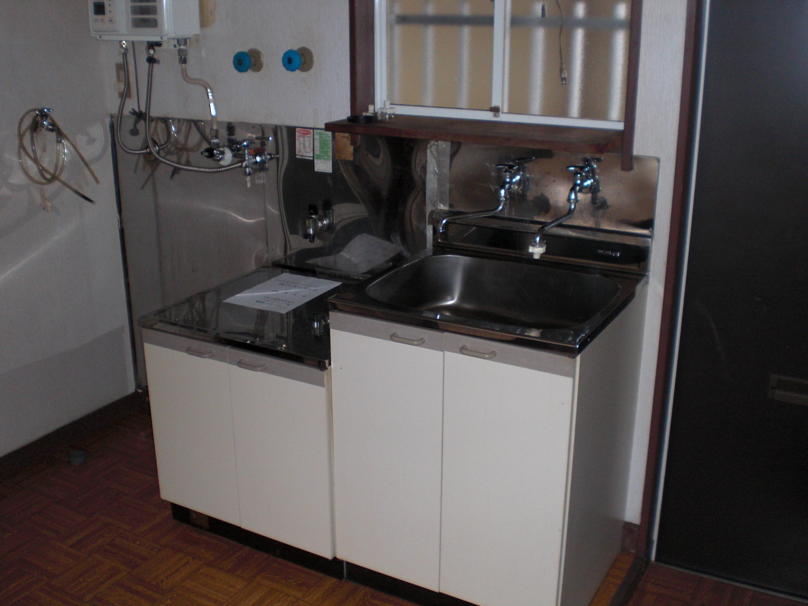Kitchen. There is a washing machine storage to the left side of the sink