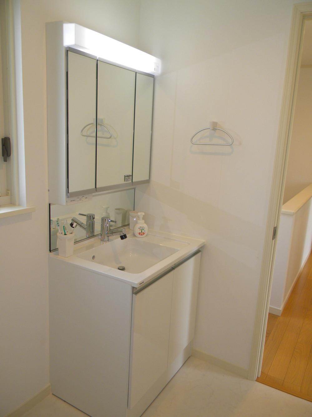Wash basin, toilet. Three-sided mirror vanity that also includes Building E washroom storage