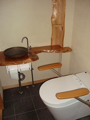 Toilet. Toilet with a wash basin is equipped with a handrail