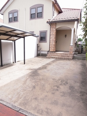 Parking lot. There is a parking space and bicycle parking lot with a roof in front of the house.