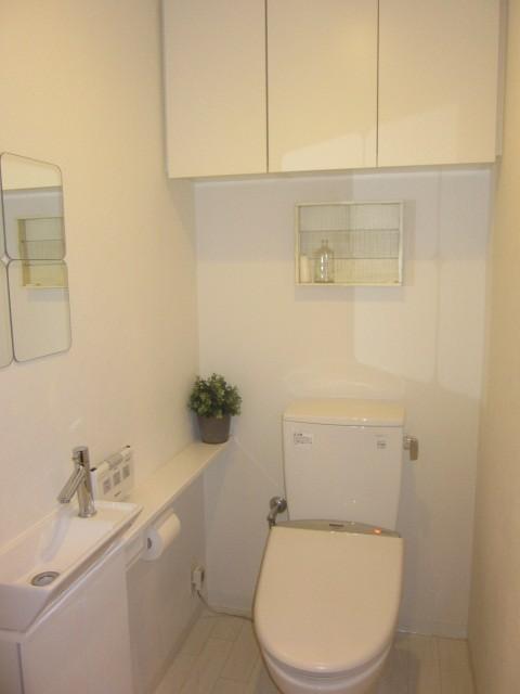 Toilet. Hand-wash facilities are attached separately, It comes with a top hanging cupboard.