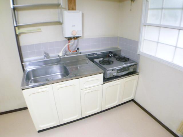 Kitchen. Two-necked gas stove left behind. Firmly workbench. 