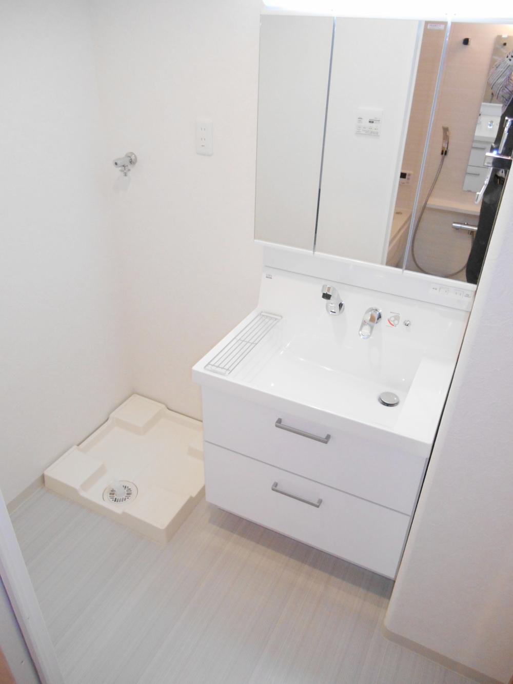 Wash basin, toilet. It is a washroom with a vanity with shower