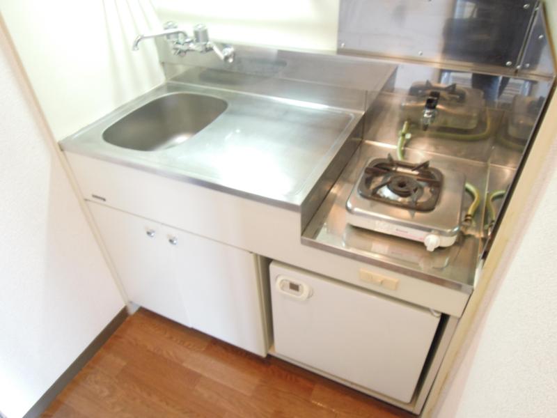 Kitchen. The kitchen is a gas stove. With a mini fridge.