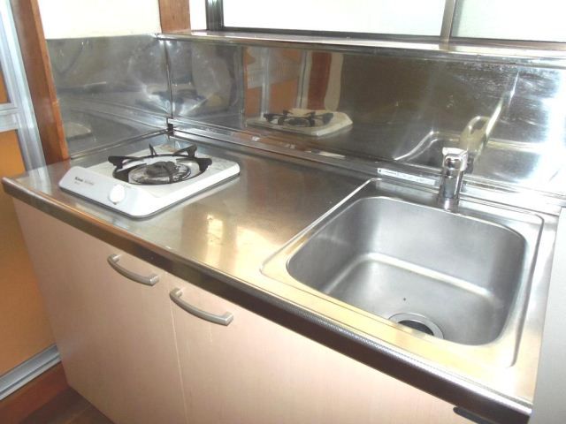 Kitchen. It is a mouthful gas stove. Bright kitchen with window.