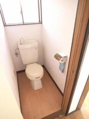 Toilet. It is bright and there is a large ventilation window in the restroom