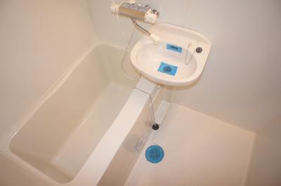 Bath. It is a clean bath equipped with a wash basin.