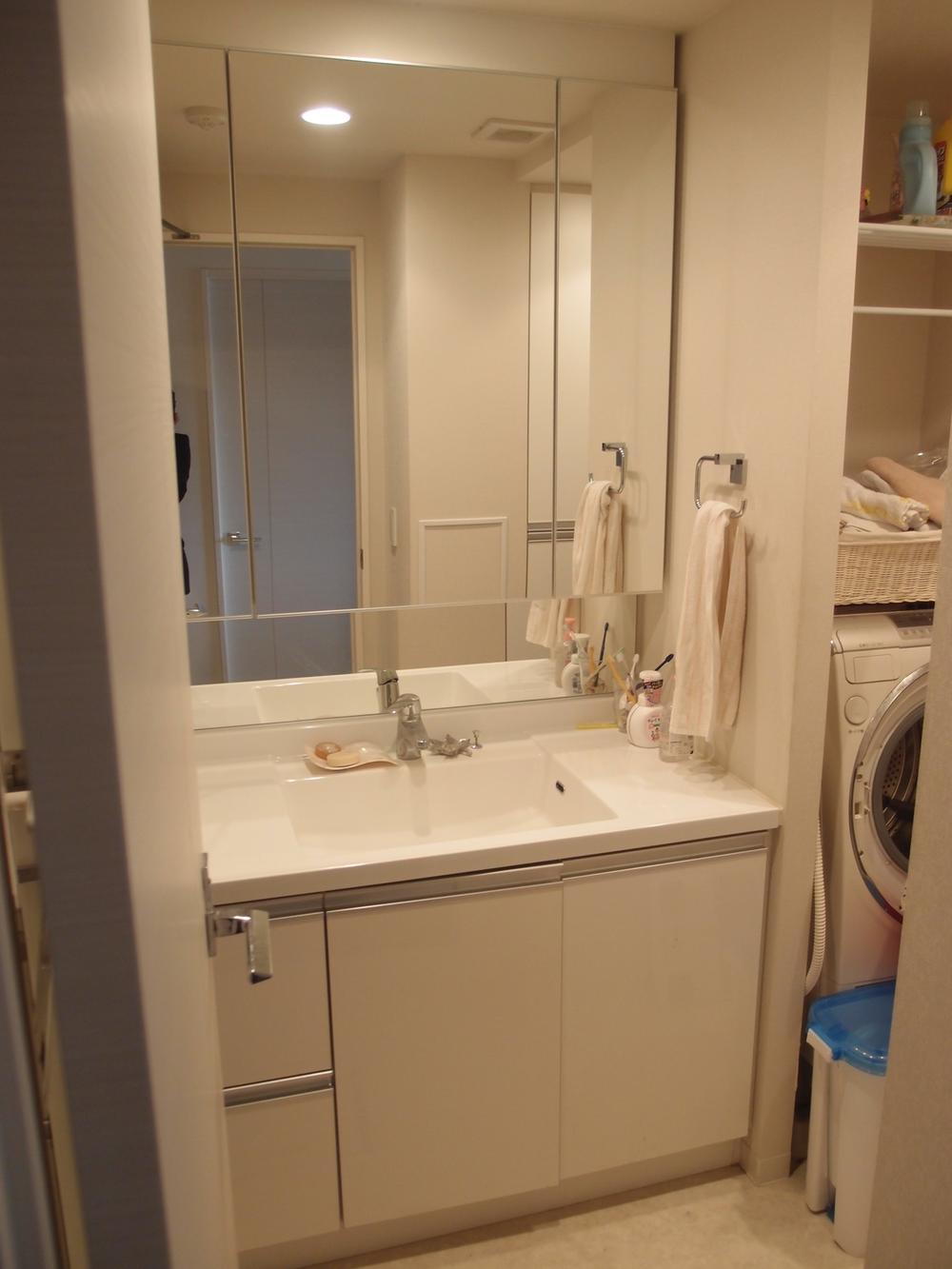Wash basin, toilet. Three-sided mirror with vanity