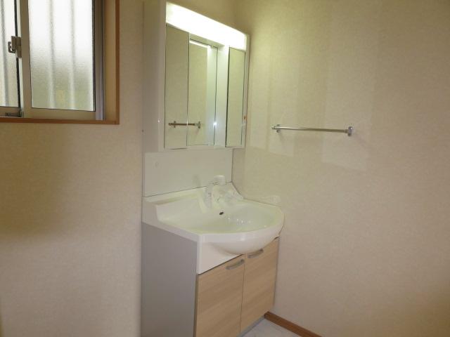Wash basin, toilet. Three-sided mirror vanity is abundant storage.