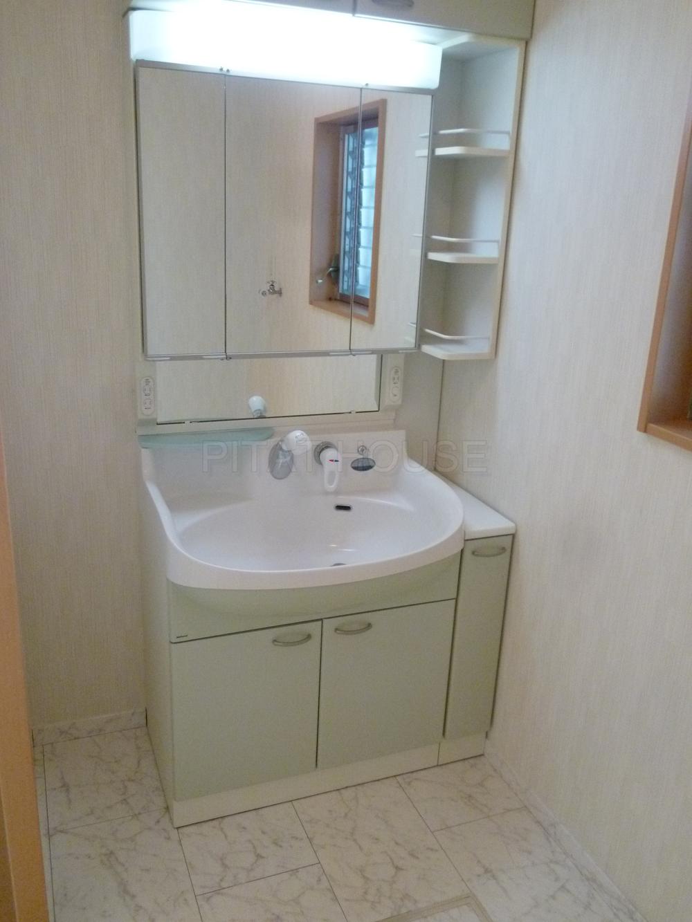 Wash basin, toilet.  ◆ Basin is a vanity with a large triple mirror.