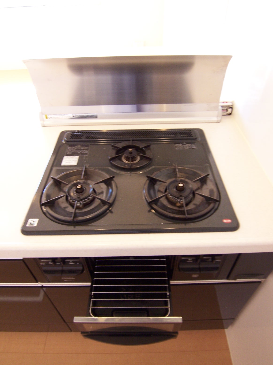 Kitchen. You width of dishes is spread in a three-burner stove and grill