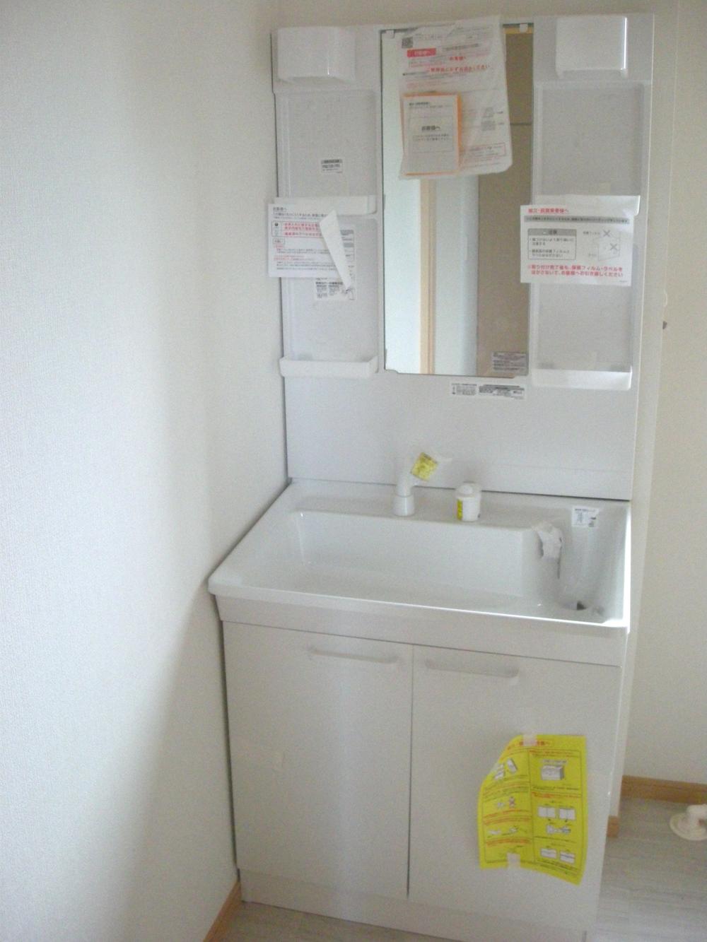 Wash basin, toilet. A large mirror