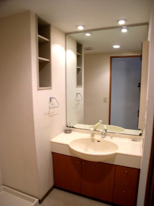 Wash basin, toilet. Vanity with a large mirror.