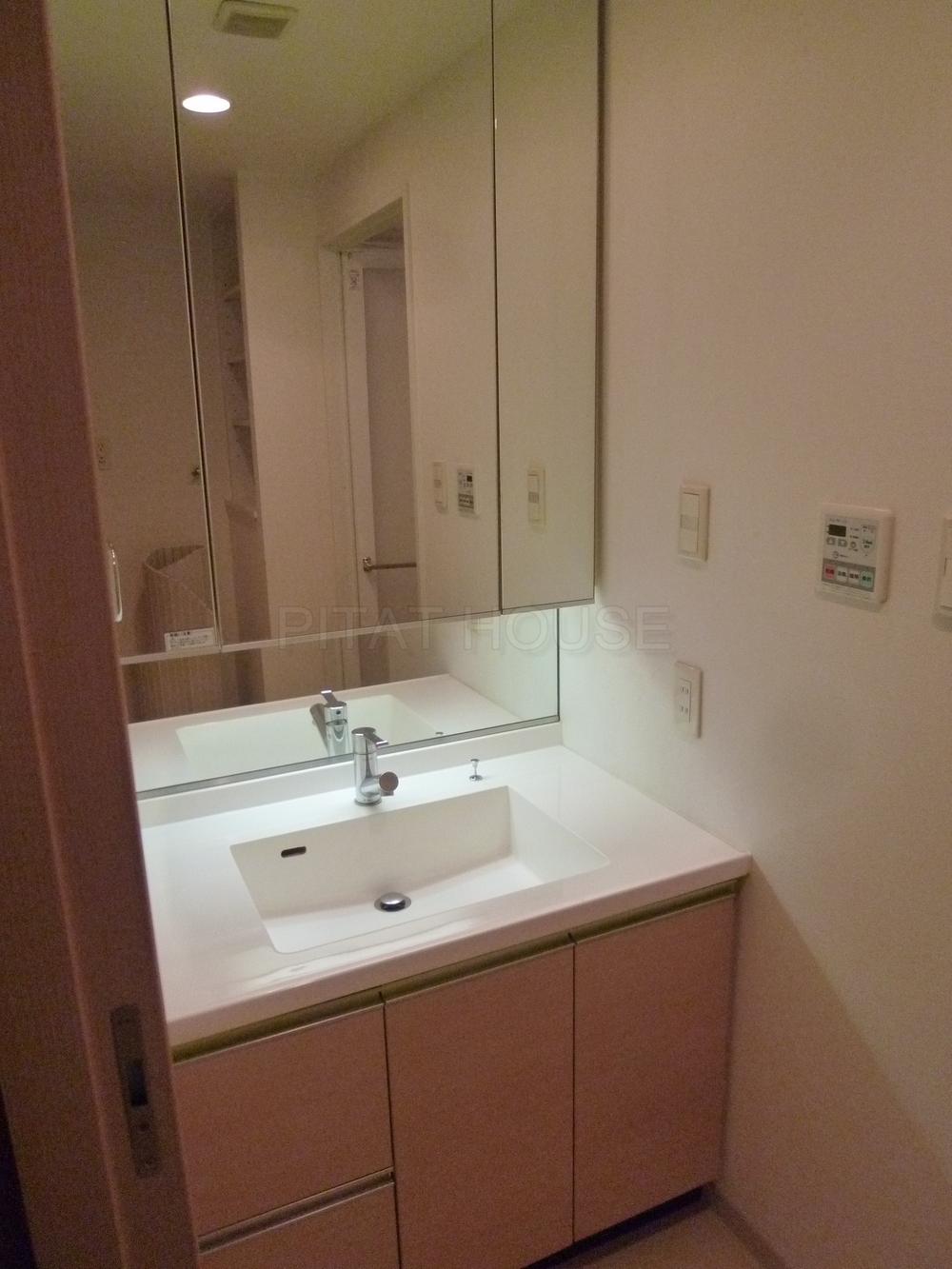 Wash basin, toilet.  ◆ Basin is a vanity with a stylish three-sided mirror.