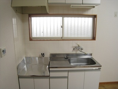 Kitchen. There is a window with natural light before the kitchen