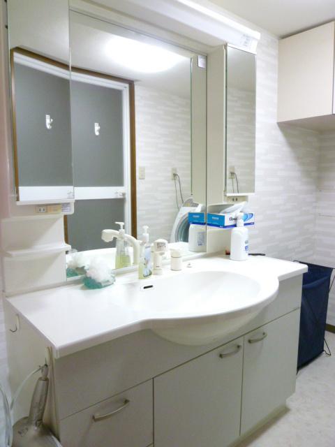 Wash basin, toilet. Large mirror distinctive vanity is shower faucet.