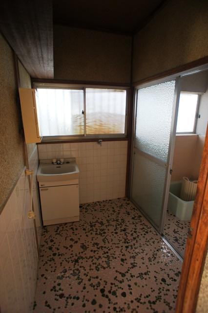 Wash basin, toilet. Tiled unusual washroom