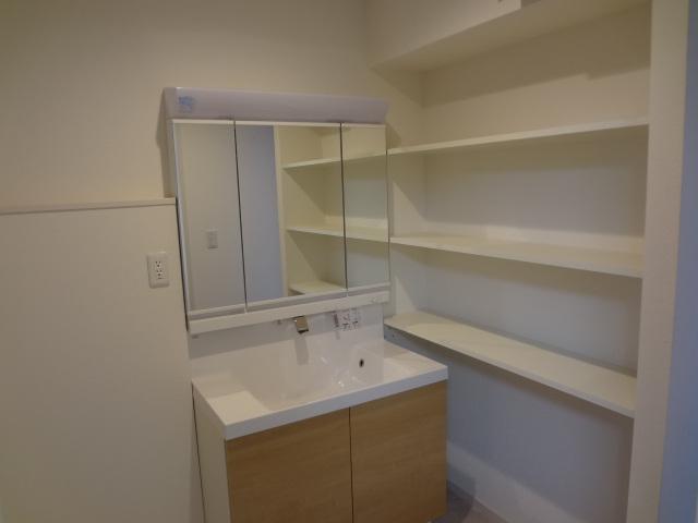 Wash basin, toilet. Basin shelf can hold towels