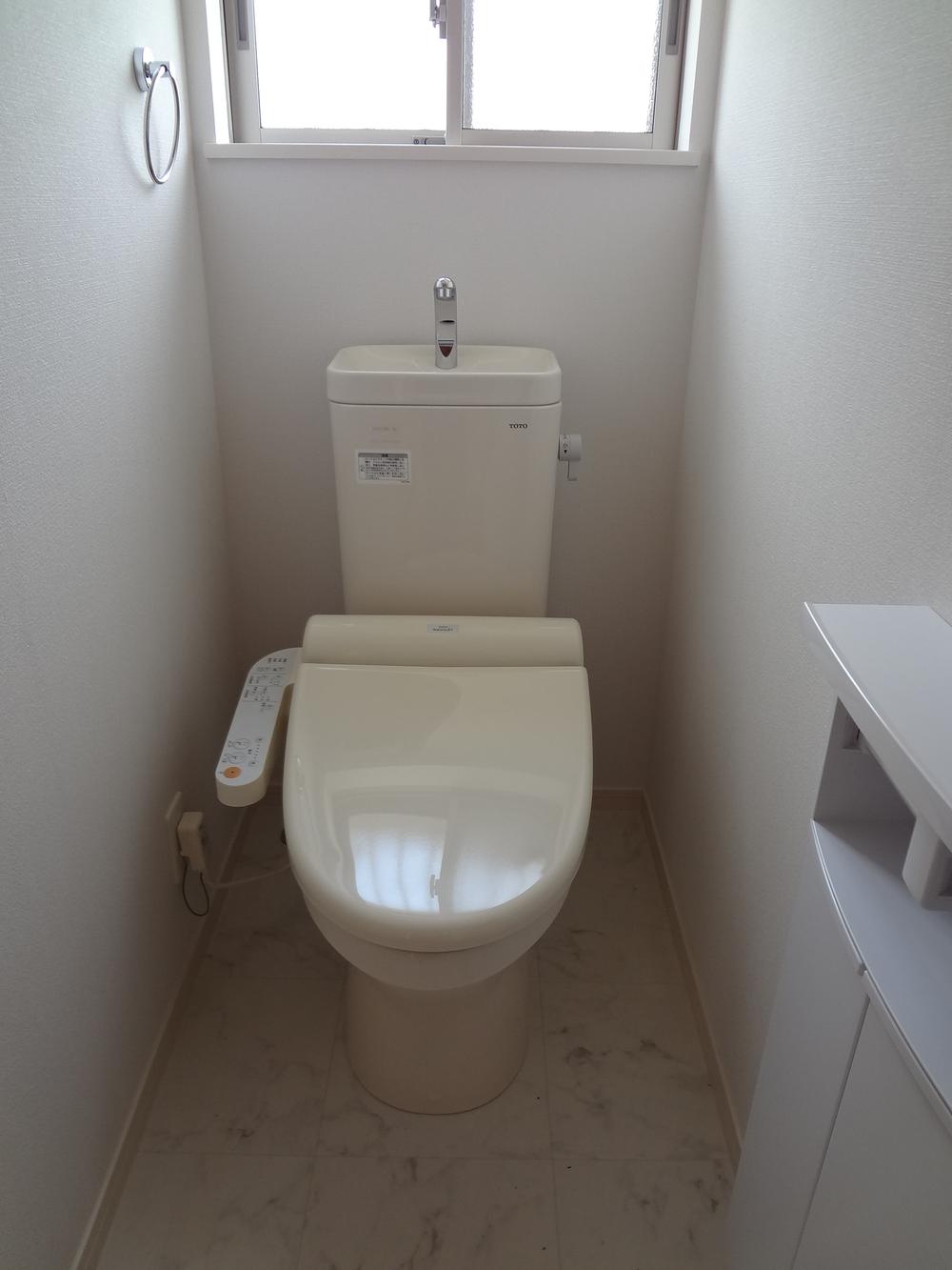 Toilet. There is a storage with paper folder.