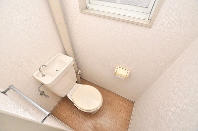 Toilet. It is bright with a window.