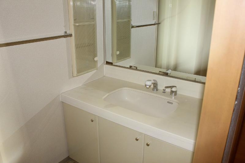 Wash basin, toilet. It is a vanity with a large mirror with.