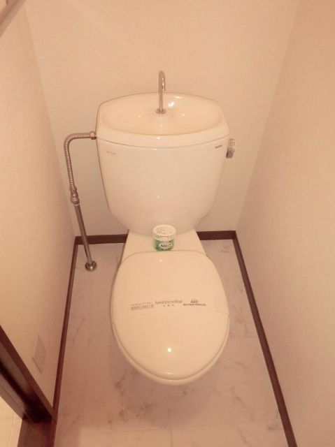 Toilet. It is a toilet with a clean, There is a shelf on the top. 