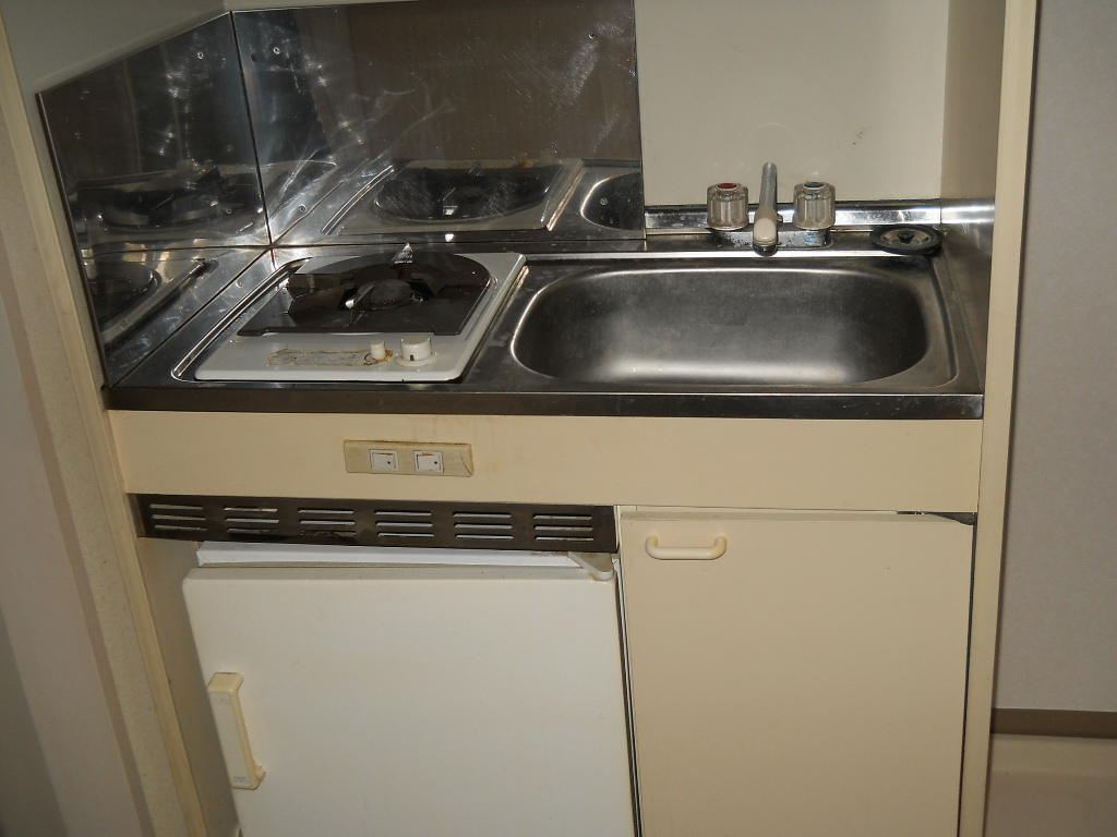 Kitchen. It is a gas stove. With a mini fridge in the lower