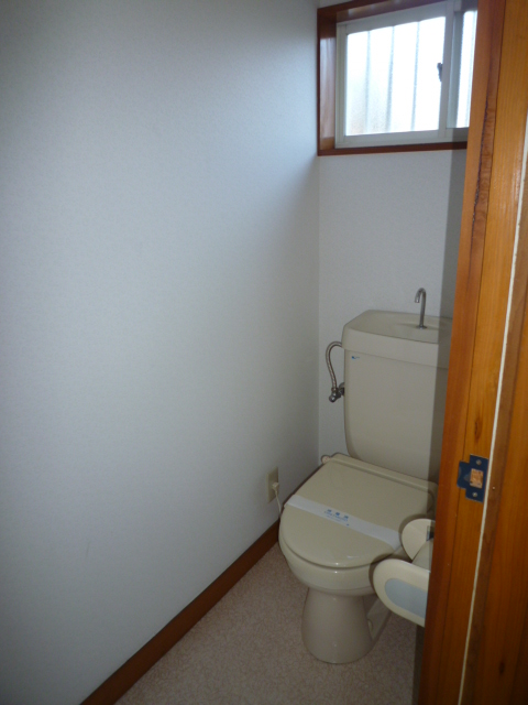 Toilet. There is a window is bright.