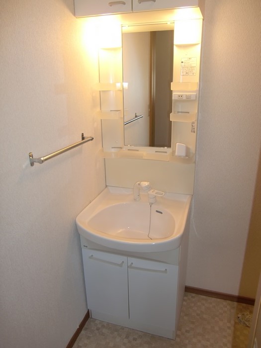 Washroom. Wash basin is with shower. There is hanging storage. 