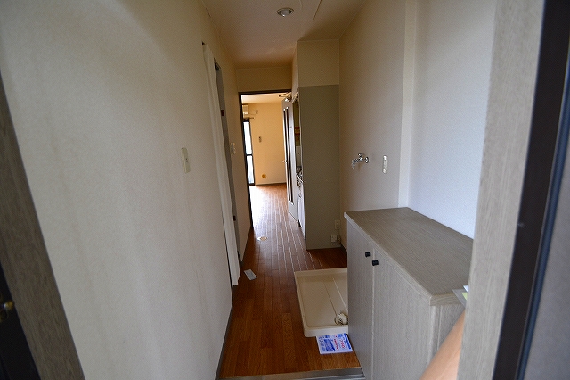 Entrance. It is a photograph from the front door. There is a kitchen and a laundry room