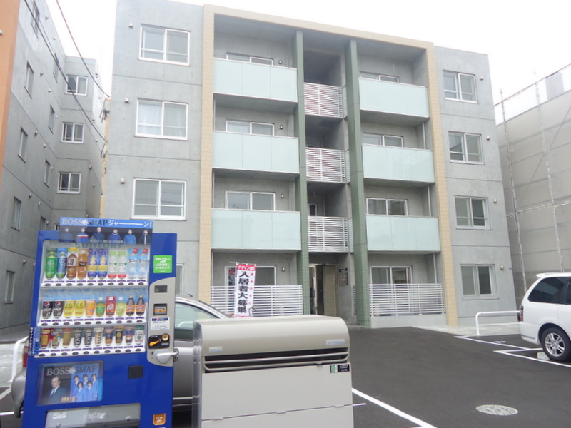 Building appearance. Private garbage dump and a vending machine in front of the eye