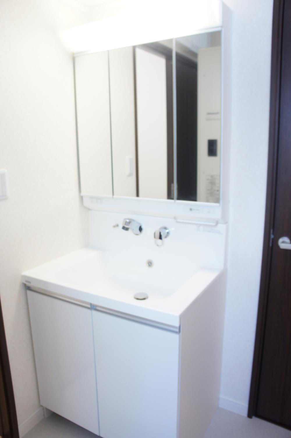 Wash basin, toilet. Bright three-sided mirror