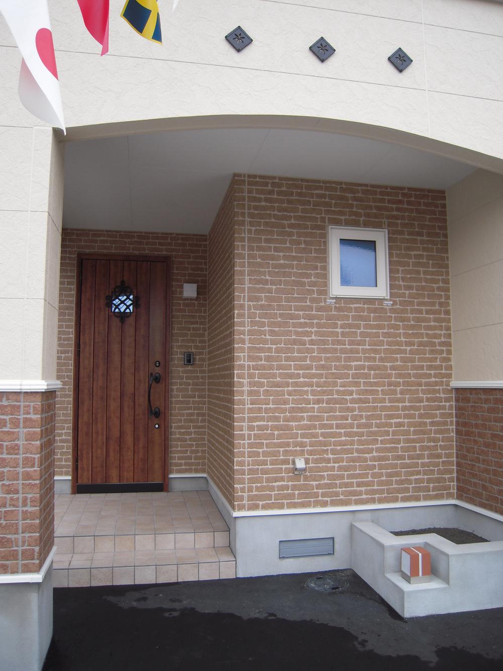 Local appearance photo. R marked with walls characteristic entrance porch. The right side flower bed space.