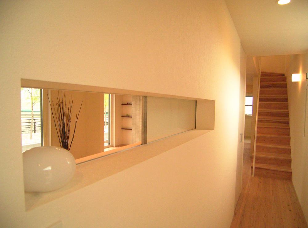 Model house photo. Small window of the corridor leading to the living room, To cabinet. It is a nice accent of house. 