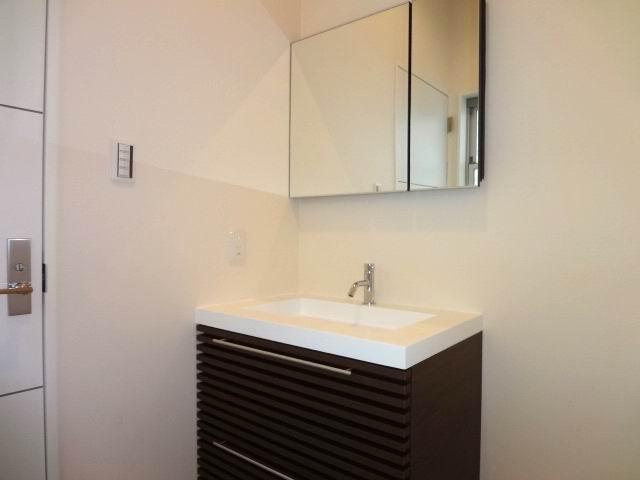 Wash basin, toilet. First floor powder room. Stylish bathroom vanity. Miller is with cabinet. 