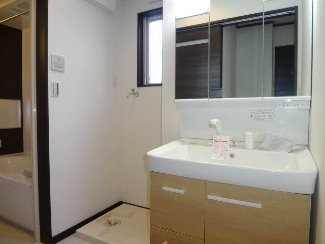 Wash basin, toilet. First floor powder room. Shampoo dresser with a three-way mirror cabinet.