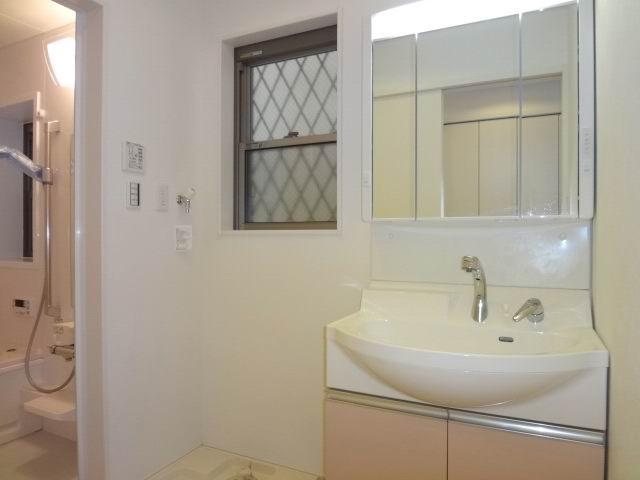 Wash basin, toilet. First floor powder room. Shampoo dresser with a three-way mirror cabinet.
