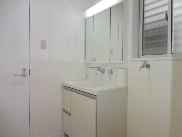 Wash basin, toilet. First floor powder room. Shampoo dresser with a three-way mirror cabinet. 